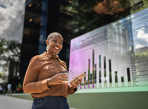 Smiling person holding a tablet in front of a floating bar chart graphic, illustrating data analysis