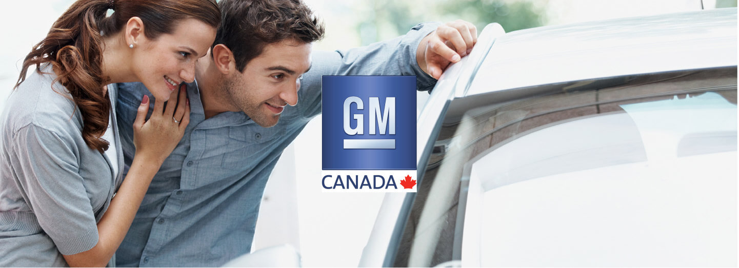 Young couple admiring new General Motors car with GM Canada logo in the centre of the image