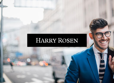 smiling man with jacket over shoulder and harry rosen logo in centre of image