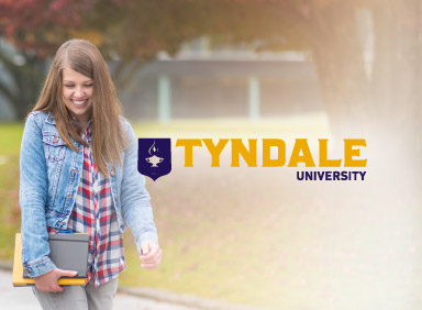 Student walking and smiling with Tyndale University logo on the right side of image