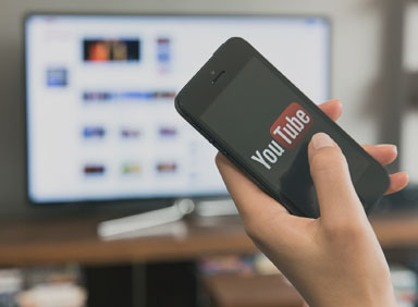 you-tube-app-on-mobile-phone-in-front-of-tv-screen