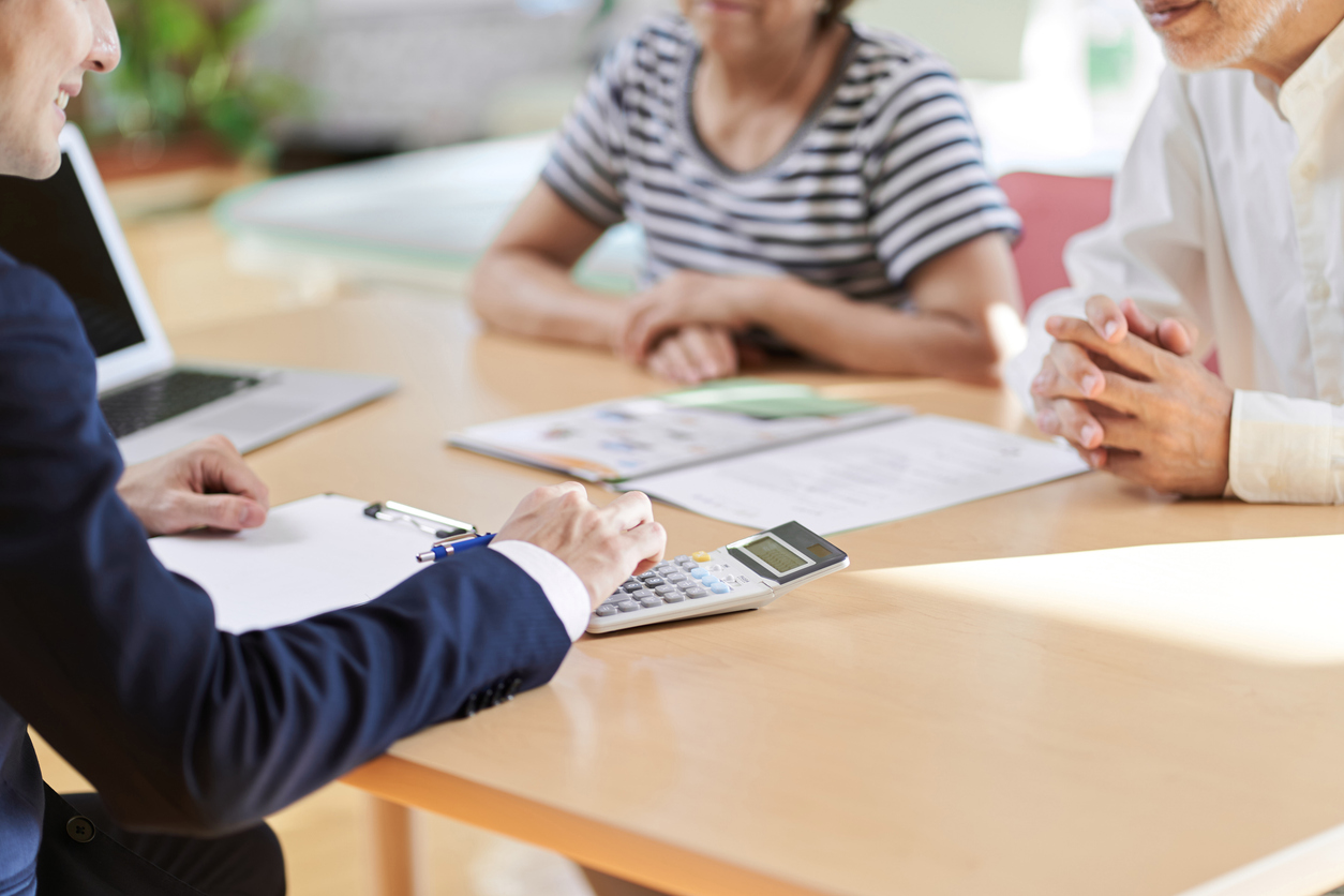 Financial advisor using a calculator and talking to clients