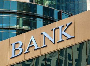 BANK sign on a glass building exterior, representing the banking industry