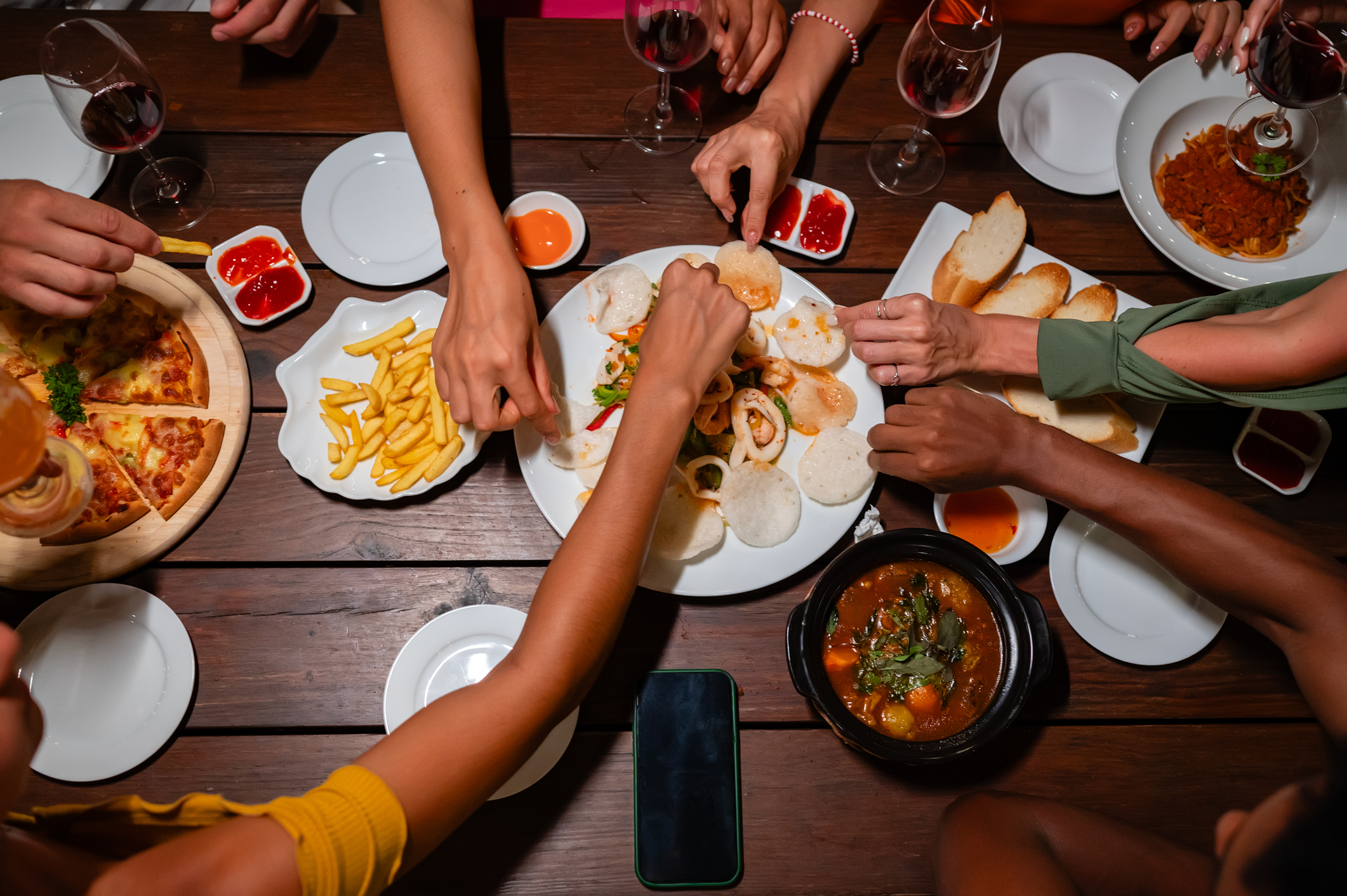 Close-up of friends sharing a delicious meal and drinks