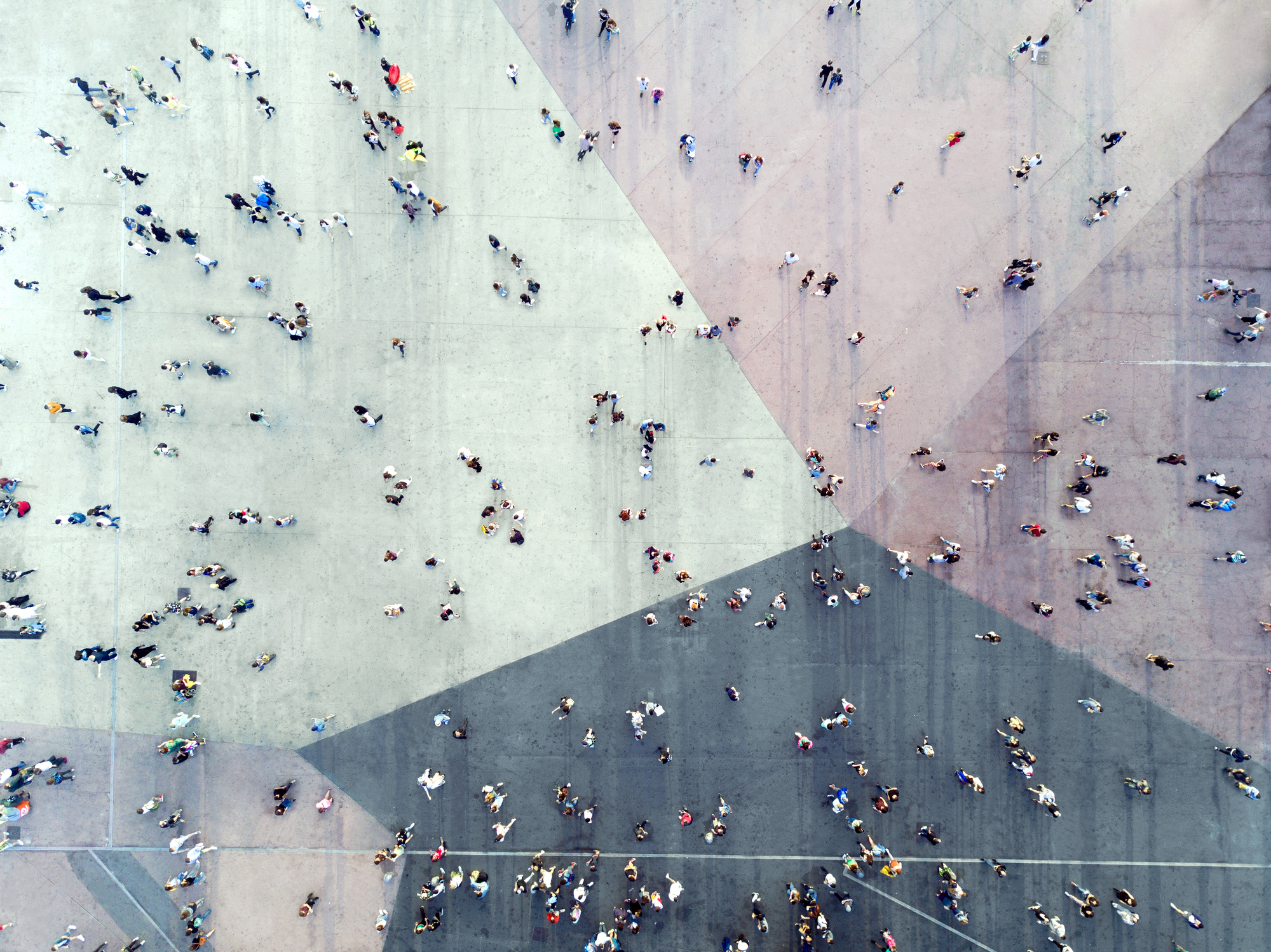 Aerial view of many people walking across a large paved plaza