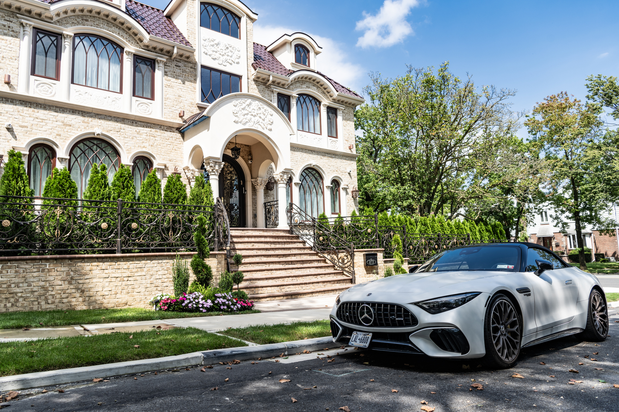 Luxury car in front of a luxury house